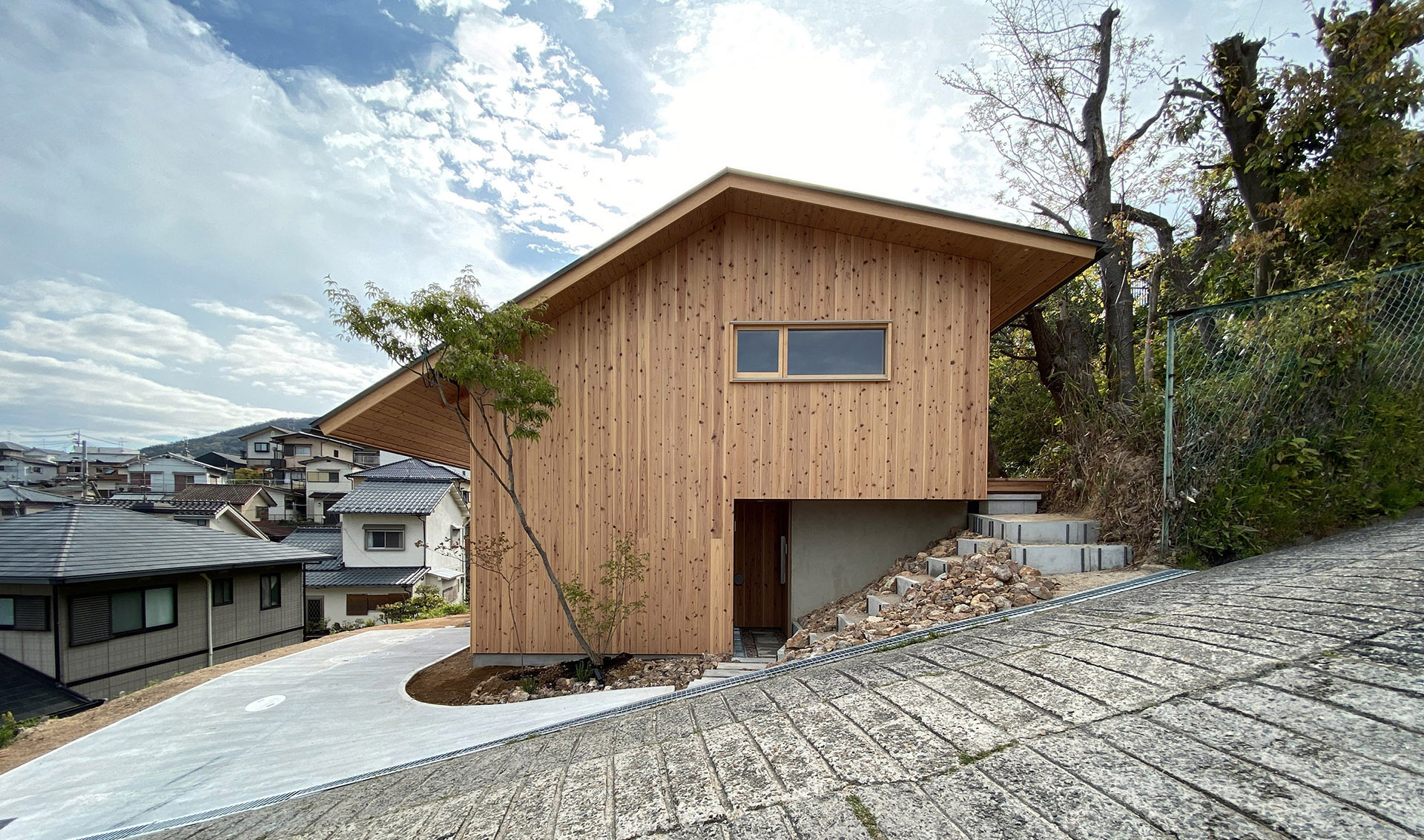 Casa de dos pisos con terraza de madera. Espacio inmerso en el centro de  una pequeña colina - timberonweb - arkitectureonweb