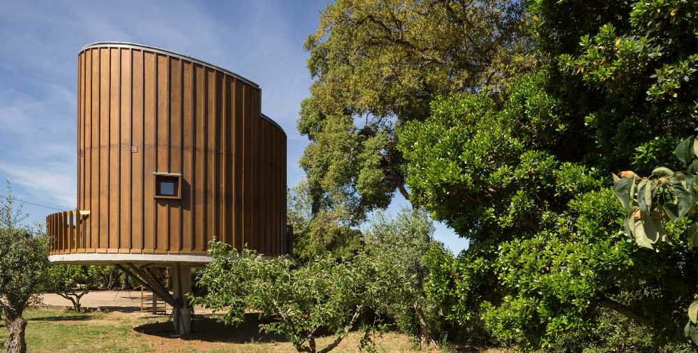 Casa de madera entre las copas de los árboles. Énfasis en el olor, tacto y el confort en el interior