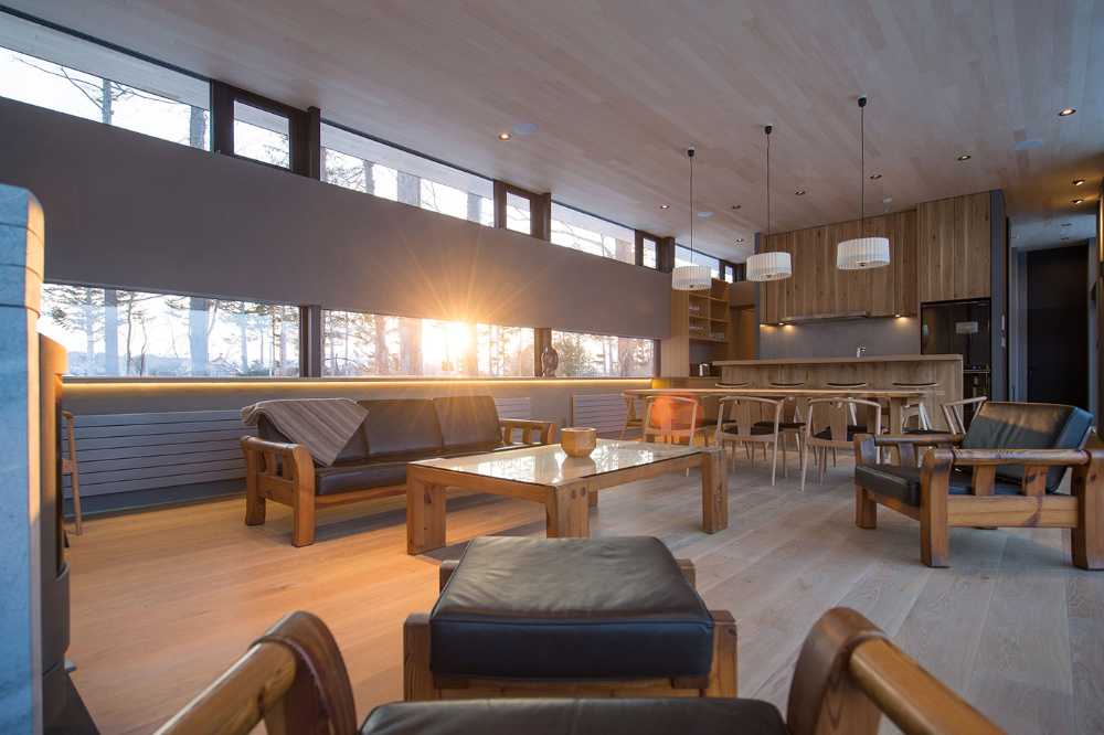 Architectural dialogue between cedar and metal for the Hiyoku house, set against the backdrop of the snow-capped mountains of Japan.