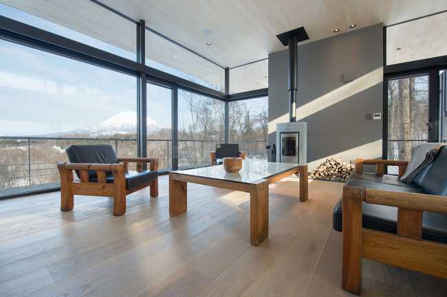 Architectural dialogue between cedar and metal for the Hiyoku house, set against the backdrop of the snow-capped mountains of Japan.