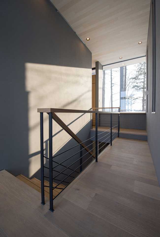 Architectural dialogue between cedar and metal for the Hiyoku house, set against the backdrop of the snow-capped mountains of Japan.