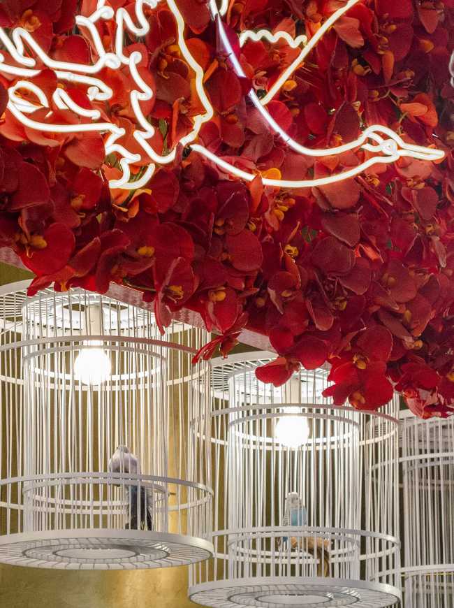 Ho Lee Chix. Red flowers and crane-shaped neon for a street food stall