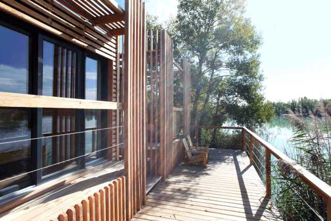 Wooden suites at the Grand Cepage Hotel, resembling the sophisticated nests among the reeds, are reflected in the lake for a primordial living experience