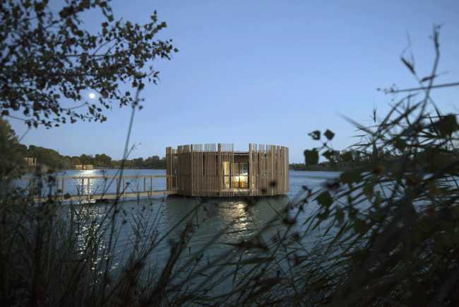 Wooden suites at the Grand Cepage Hotel, resembling the sophisticated nests among the reeds, are reflected in the lake for a primordial living experience