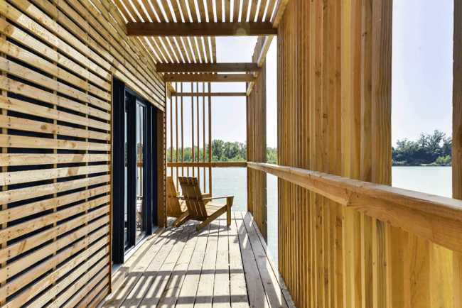 Wooden suites at the Grand Cepage Hotel, resembling the sophisticated nests among the reeds, are reflected in the lake for a primordial living experience