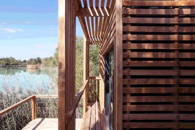 Wooden suites at the Grand Cepage Hotel, resembling the sophisticated nests among the reeds, are reflected in the lake for a primordial living experience