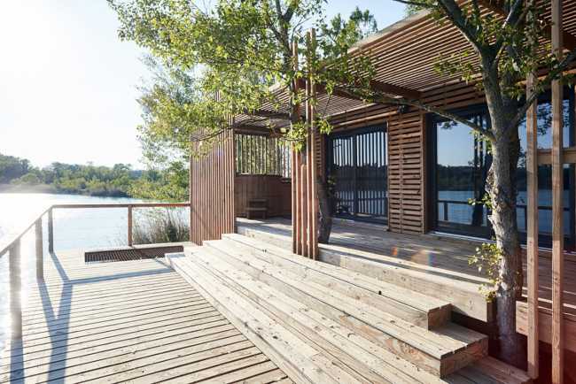 Wooden suites at the Grand Cepage Hotel, resembling the sophisticated nests among the reeds, are reflected in the lake for a primordial living experience