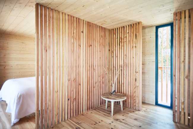 Wooden suites at the Grand Cepage Hotel, resembling the sophisticated nests among the reeds, are reflected in the lake for a primordial living experience