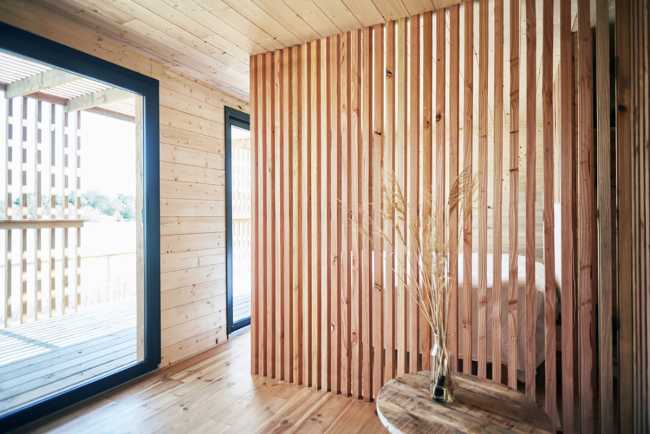 Wooden suites at the Grand Cepage Hotel, resembling the sophisticated nests among the reeds, are reflected in the lake for a primordial living experience