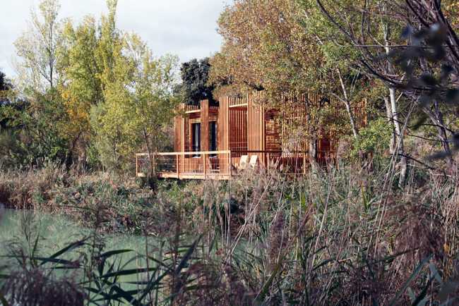 Wooden suites at the Grand Cepage Hotel, resembling the sophisticated nests among the reeds, are reflected in the lake for a primordial living experience