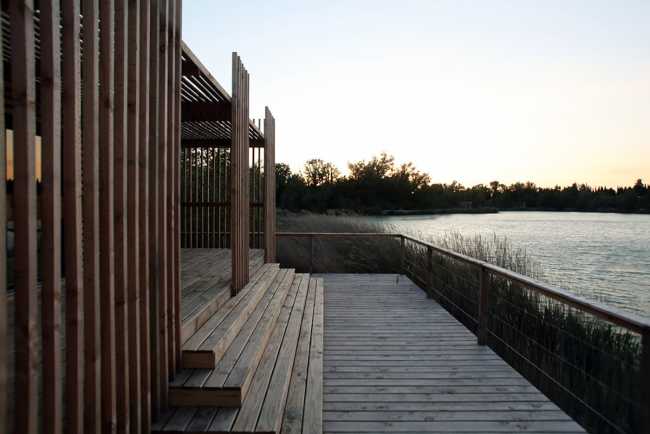 Wooden suites at the Grand Cepage Hotel, resembling the sophisticated nests among the reeds, are reflected in the lake for a primordial living experience