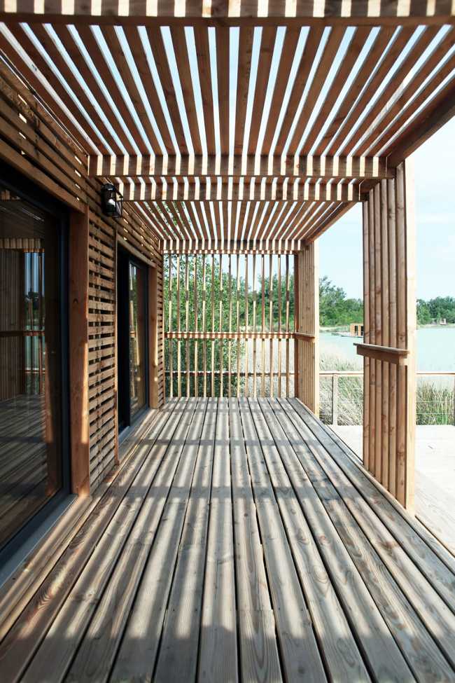 Wooden suites at the Grand Cepage Hotel, resembling the sophisticated nests among the reeds, are reflected in the lake for a primordial living experience