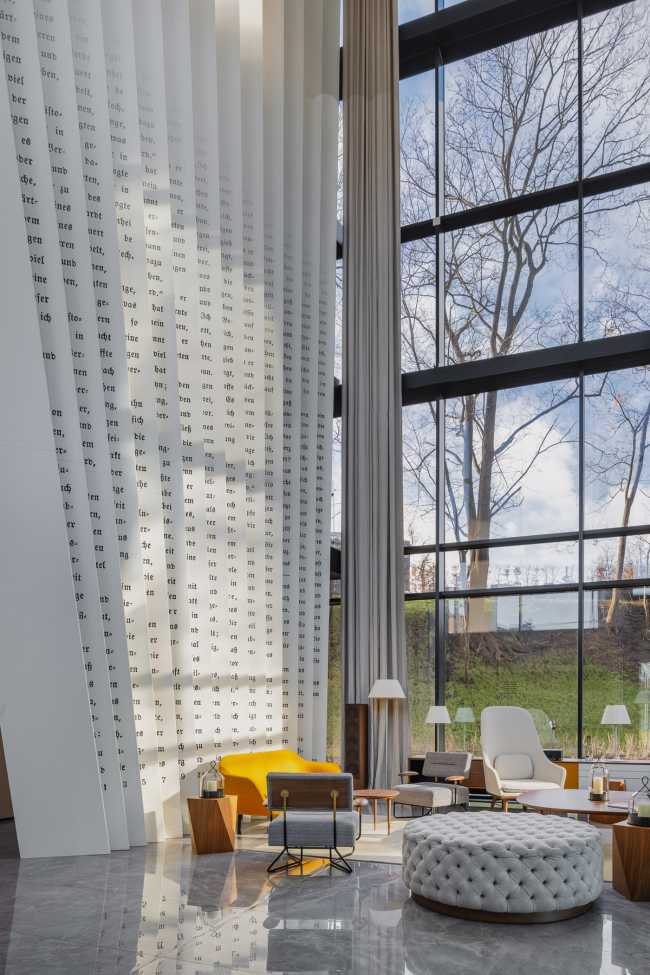 Huge wooden books create the space for the Lobby of the Philosophers Residence in Latvia