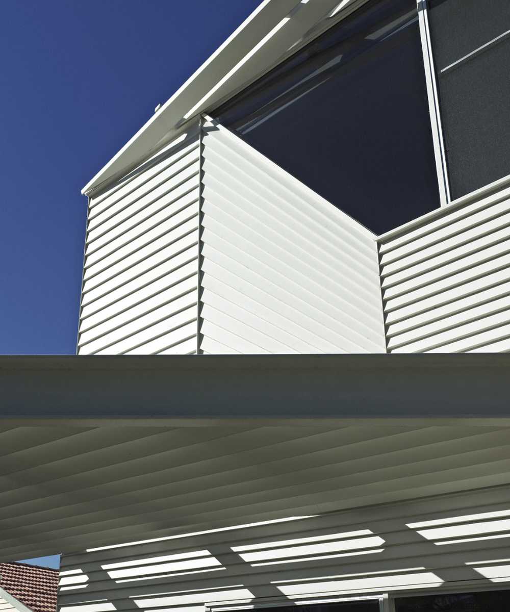 Wooden house with play of light and shadow on the terrace
