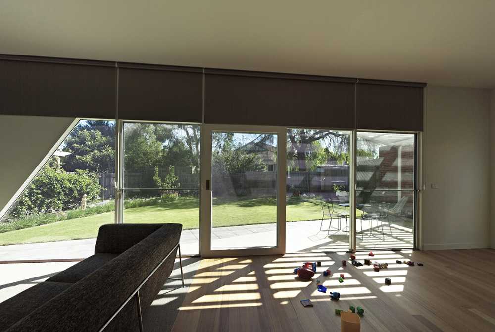 Wooden house with play of light and shadow on the terrace