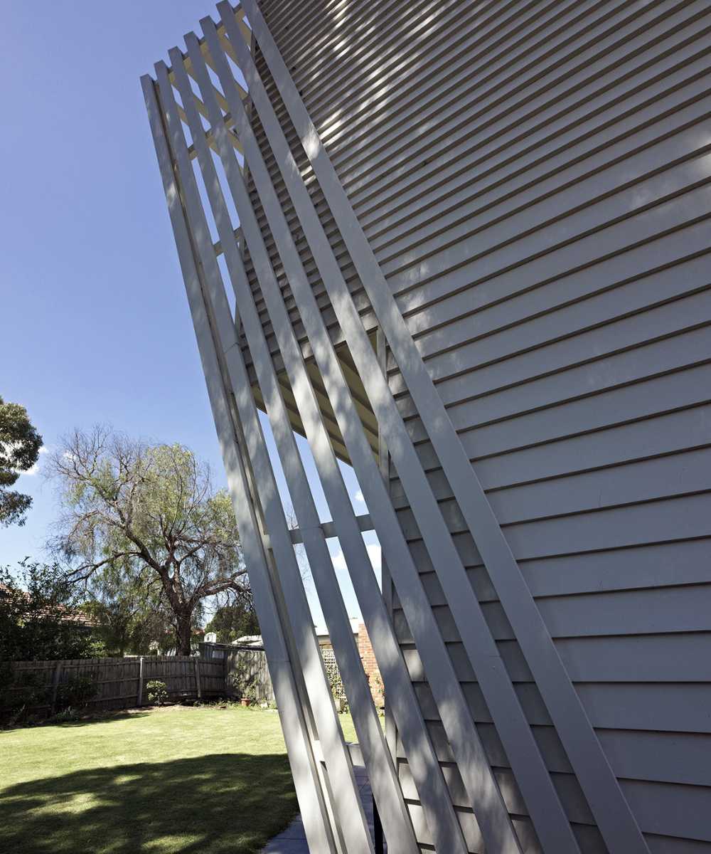 Wooden house with play of light and shadow on the terrace