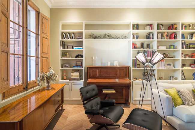 living room with piano armchairs and bookcase
