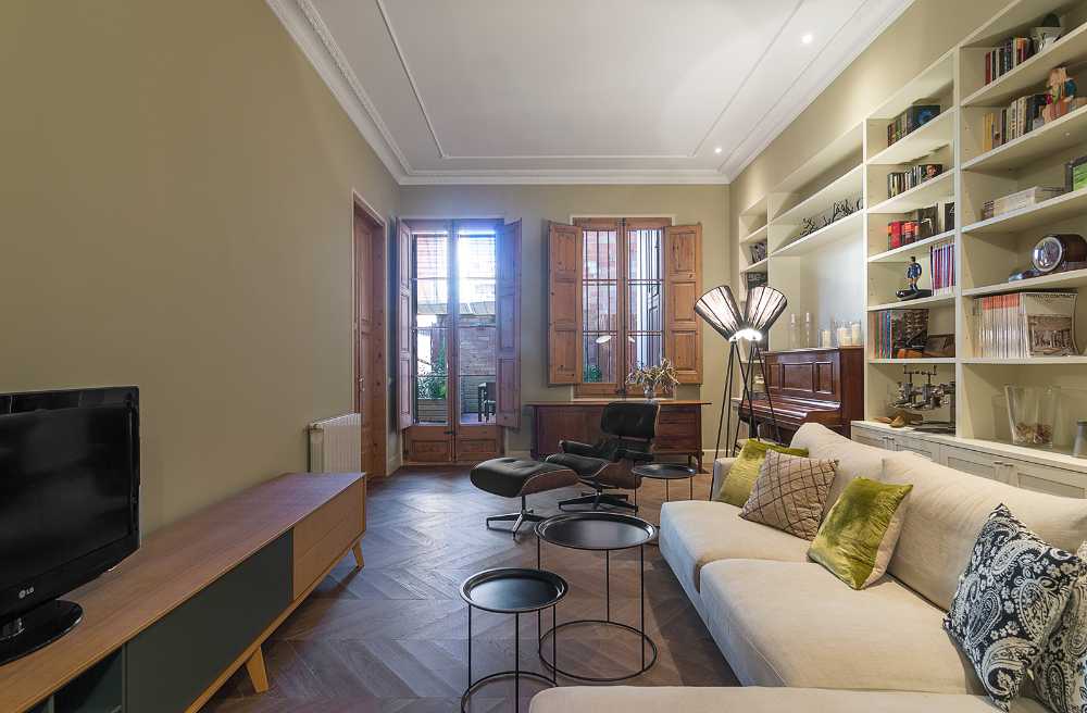 living room with piano armchairs and bookcase