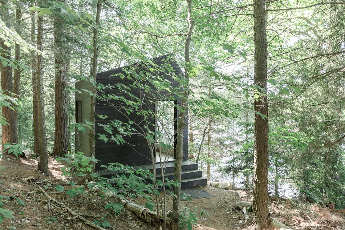 h-shaped-cabin-the-dark-wood-blends-elegantly-into-the-pine-forest