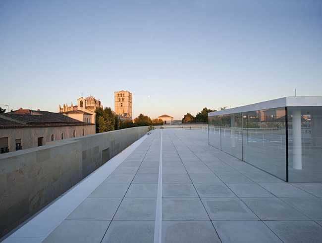 office building glass facade continuous stone flooring terrace