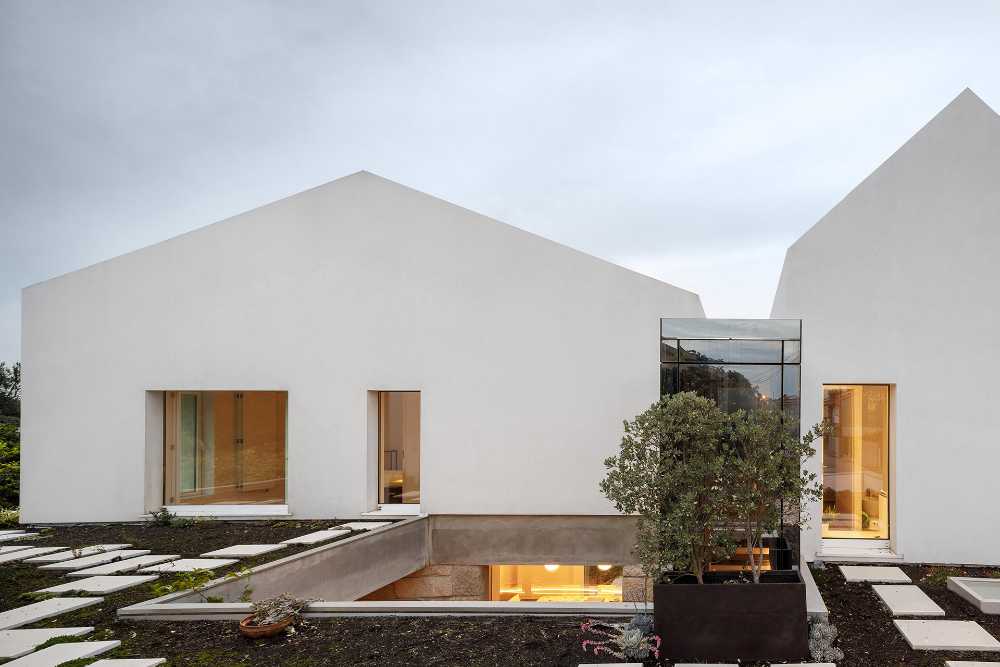 Old renovated farmhouse. Three white volumes stand on a rustic ground floor