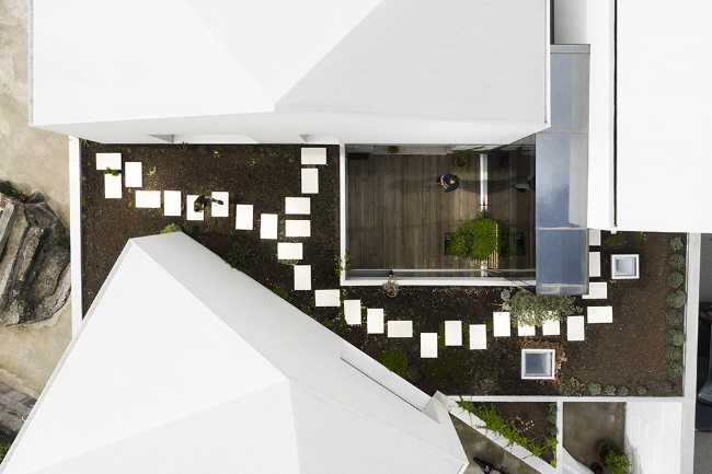 Old renovated farmhouse. Three white volumes stand on a rustic ground floor