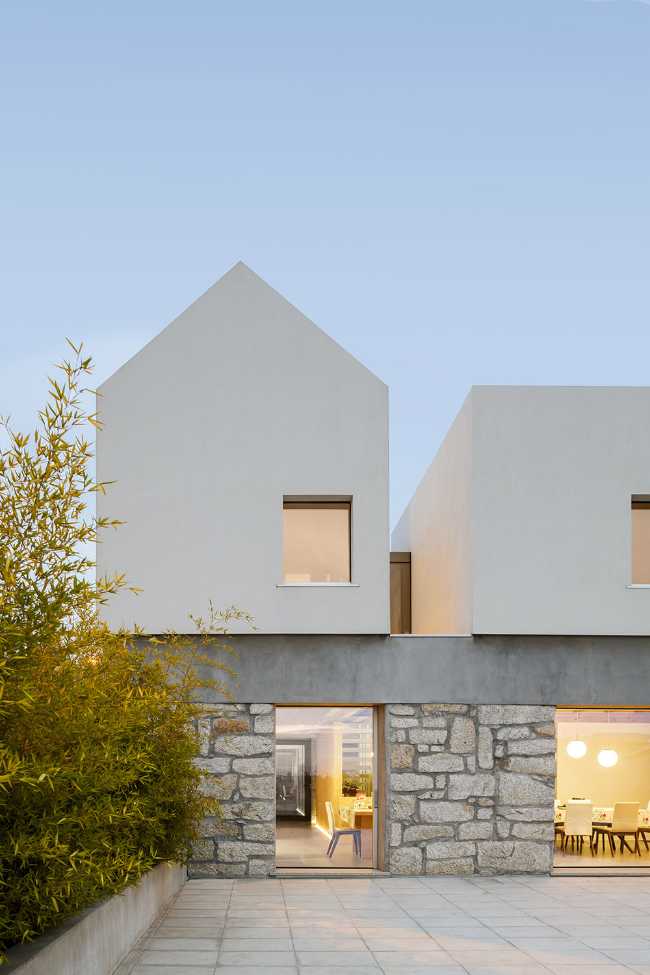 Old renovated farmhouse. Three white volumes stand on a rustic ground floor