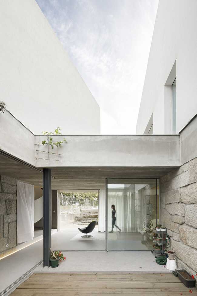 Old renovated farmhouse. Three white volumes stand on a rustic ground floor