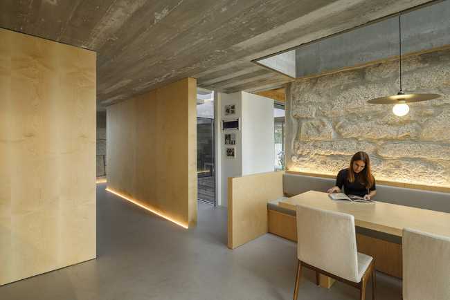 Old renovated farmhouse. Three white volumes stand on a rustic ground floor