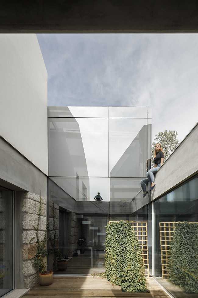 Old renovated farmhouse. Three white volumes stand on a rustic ground floor