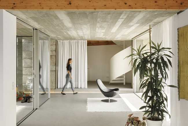 Old renovated farmhouse. Three white volumes stand on a rustic ground floor