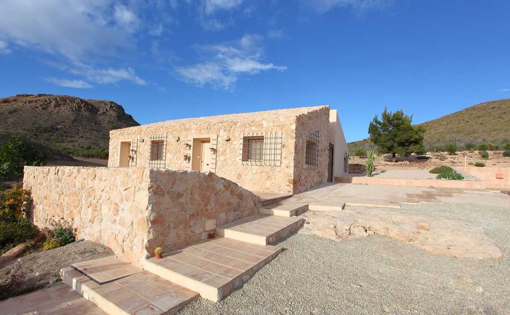 Mediterranean house situated between ploughed fields and stones. Ecological habitat in Spain